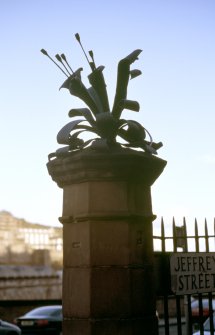 View of sculpture 'Honeysuckle', on stone pillar at end of railings on Jeffrey Street.