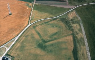 Oblique aerial view centred on the cropmarks of the moated site, taken from the west north west.