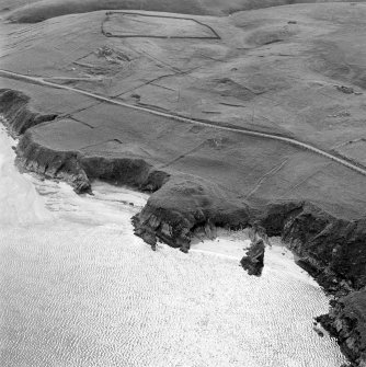 Oblique aerial view centred on the remains of the broch with the remains of the farmsteads, enclosures, structures, head-dyke and field-system adjacent, taken from the ENE.