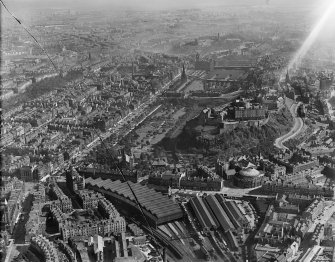 Edinburgh, general view, showing Edinburgh Castle and Princes Street Gardens.  Oblique aerial photograph taken facing north-east.  This image has been produced from a damaged negative.