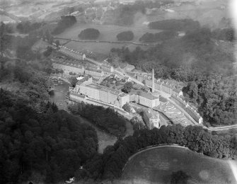 New Lanark, general view, showing Gourock Ropework Co. Ltd. Mills and New Lanark Road.  Oblique aerial photograph taken facing north.