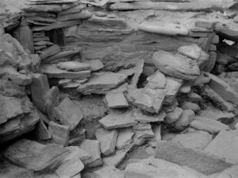 Excavation photograph: House 2, Tumbled stones filling S. W. corner of house, between passage entrance ( top left ) and main entrance ( top right ).

