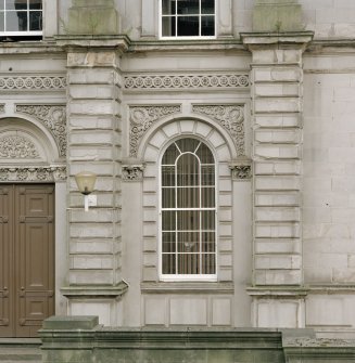 Detail of ground floor window with decorative carved surround.