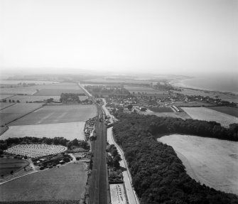 Longniddry, general view, showing Main Street and Fernyness Wood.  Oblique aerial photograph taken facing west.