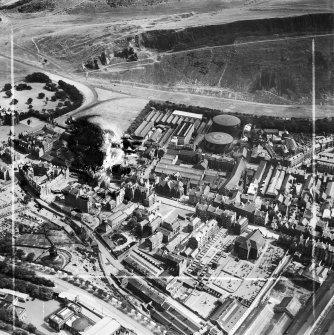 Edinburgh, general view, showing William Younger and Co. Ltd. Holyrood Brewery and Canongate Parish Church.  Oblique aerial photograph taken facing south-east.  This image has been produced from a damaged and crop marked negative.