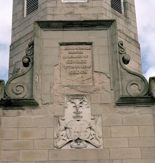 Detail of memorial plaque with coat of arms below.