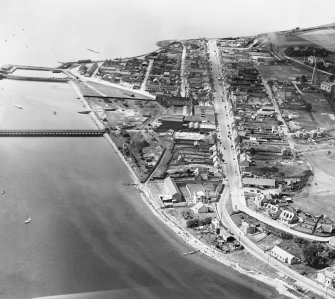 Invergordon, general view, showing High Street and Royal Naval Dockyard.  Oblique aerial photograph taken facing west.