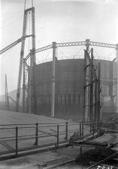 General view of new spiral guided gas holder uninflated, showing spiral stairway and erection mast, with Number 5 gas holder in background, Meadow Flat Gasholder Station, Holyrood Road, Edinburgh.