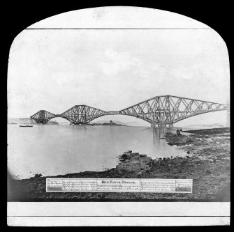Composite photograph of an artist's impression of the bridge seen from the South West shore.
Insc. 'The Forth Bridge. Engineers Sir John Fowler, B. Baker Esq. Length including Viaduct 8098 Feet. Length of Central Girder 350 Feet. Width of Central Girder 28 Feet. Diameter of Largest Tubes 12 Feet. Height extreme 369 Feet. Spans each 1710 Feet. Headway 150 Feet. Diameter of Piers 49 Feet. Length of three Cantilevers 5350 Feet.  Width of each Cantilever top 33 Feet. Depth at end of Cantilever 40 Feet. Depth at end of Cantilever 40 Feet. Diameter of smallest Tubes 3 Feet. Contractors Tanered Arrol & Co. Copyright Entered at Stationershall.'
Lantern slide.