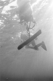 Secure under the flotation bag, a lead ingot is towed ashore.