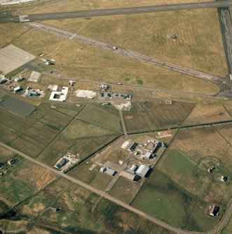 Digital copy of oblique aerial view centred on the village with the airfield adjacent, taken from the SSE.