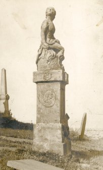 Scanned image of photograph of scuplture by John Nicolson of a boy seated on a pedestal in Canisbay Churchyard