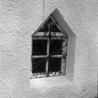 Detail of pointed window with iron grille