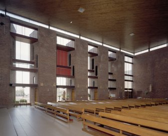 Interior. View of vertical glazing bands and pews
