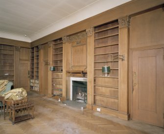 Interior. Ground floor library in W wing showing fitted pilastered bookcases