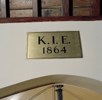 Interior. Detail of Brass plaque over entrance. Inscribed K.I.E. 1864.