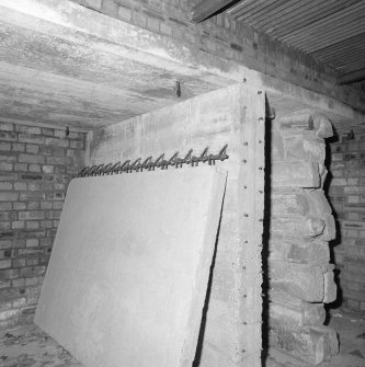 E/W Track. Hut interior with large hinged concrete door and brick partitions