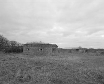 View SW to type 27 pillbox and airfield perimeter building.