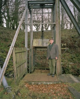 Detail of the cage, now fixed at the top of the shaft.  The owner of the mine, Kenneth Montgomerie, is standing beside the cage.