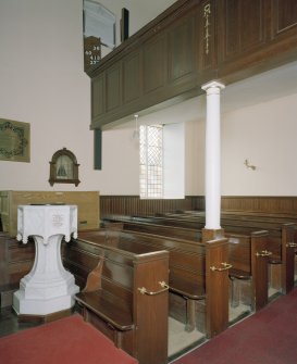 Interior. Detail of pews and octagonal stone font