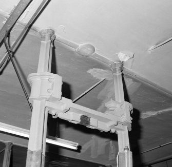 Interior.  Detail of cast iron columns at ceiling level on ground floor.