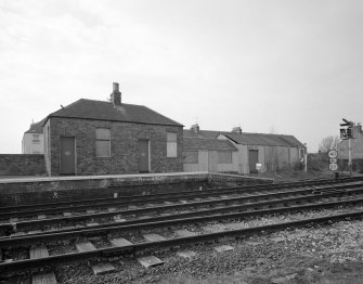 View from E of outbuilding and shed at end of N-bound platform at W side of station