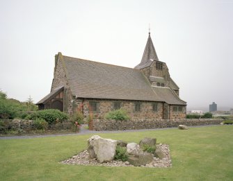 View from NE showing entrance porch and spire