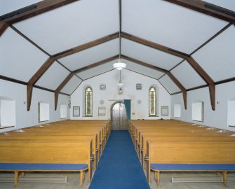 Interior. View from E showing nave, entrance and roll topped pew ends