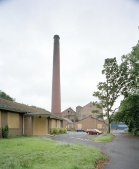 General view from NNW of N end of works, including boilerhouse chimney, and main office (foreground left)