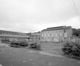 General view from N of main paper mill production block (left), and tall steel-framed brick building at NE end of complex (function not specified on site plan)