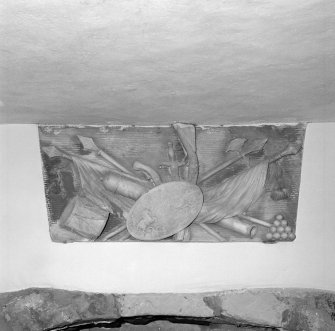 Interior.
Family room, detail of reused decorative panel of military equipment over fireplace
