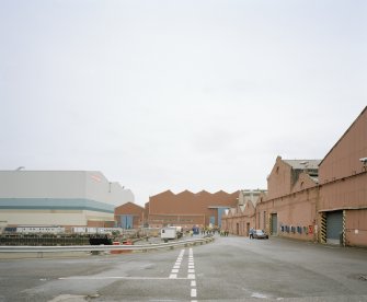 General view from W at S end of fitting-out basin, with former Plumbers' Shops to right, and former engine works beyond, and the new 'Tank Assembly Shop' to the left