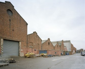 View from WSW along S side of former plumbers' shops with former engine works beyond.