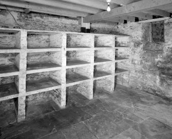 Interior. Lower ground floor View of Wine Cellar in SE wing showing wine binsfrom NW