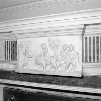 Interior. Detail of central carved panel on saloon fireplace depicting putti riding a lion