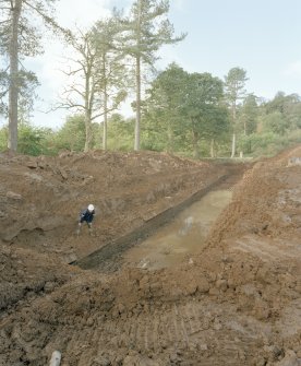 View from E of lade exposed by building-site development, with contractor in foreground