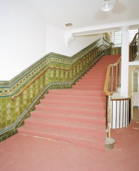 Interior, view of staircase at ground floor level with tiled dado