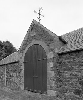 Detail of steading main arched cart entrance with  plaque inscribed "1877  WJ" with weathervane at the apex