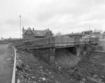 Context view from E, with road bridge over railway in forebround, showing that the line has been blocked