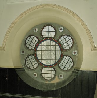 Interior. 
Detail of stained glass in wheel window at gallery level.