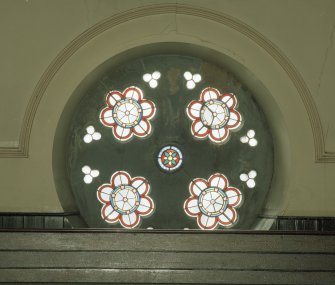 Interior. 
Detail of stained glass in wheel window at gallery level.