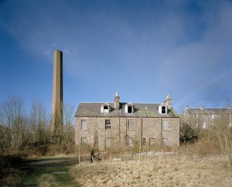 View from SE of SE side of mill, showing houses (right) and boiler house chimney (left)