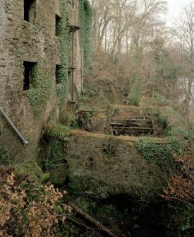 Detailed view from SE of remains of water wheel and associated lineshafts and gearing at NE side of mill