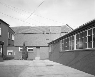 View from S of former floor-maltings block (now a store), with part of office building (left), evaporator house (right)