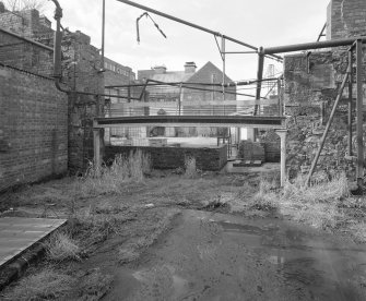 View from E within ruins of former distillery, with fabricated curved beam (centre)