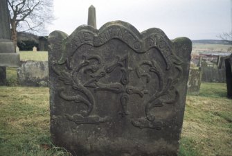 View of gravestone carved with  Memento Mori, scrolls and numeral 4, Alva churchyard.