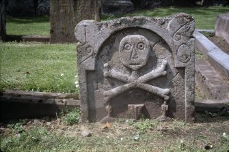 View of 17th-century headstone with skull and crossbones, Logie Old Churchyard.