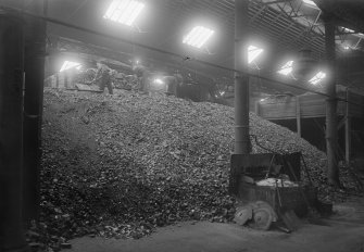 View of men at work at New Street Gasworks, Edinburgh, unloading coal from railway wagons.