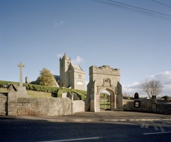 General view of gateway, war memorial and church from NW.