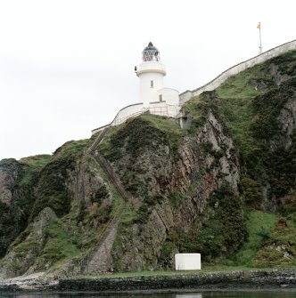 Islay, McArthur's Head Lighthouse
General view of lighthouse and compound from N (viewed from a boat at sea), showing cliff-top location, steep steps down to jetty, flagpole, and compound wall